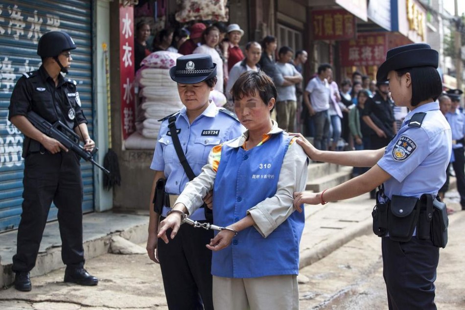 人谢某和被其"救"走的嫌疑女子(44岁,贵州盘县人),在多名特警的押解下